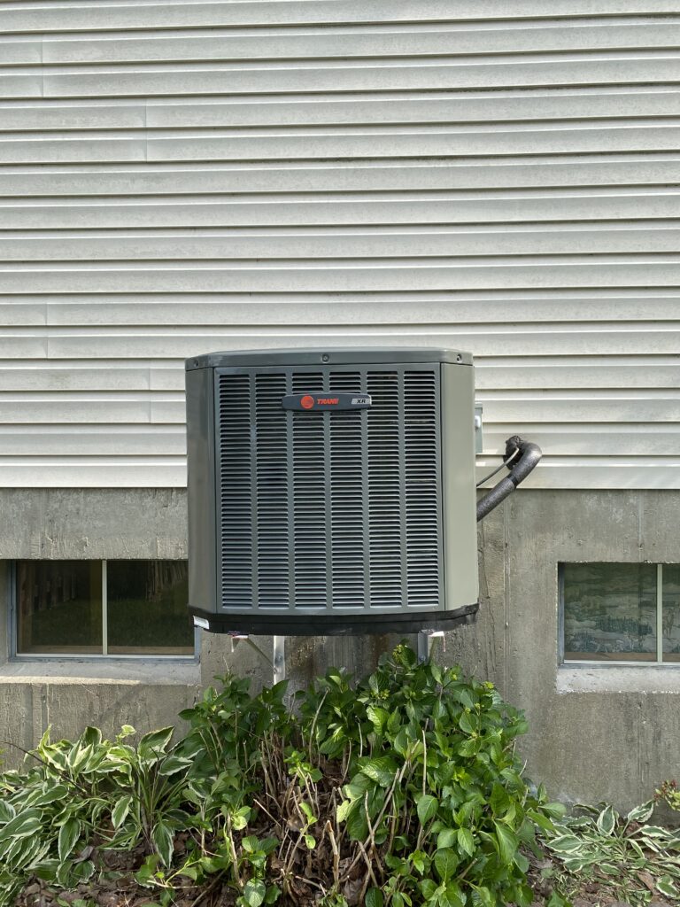 Trane AC condenser on a wall bracket, installed by Liberty Heating Cooling and Plumbing in South St. Louis County