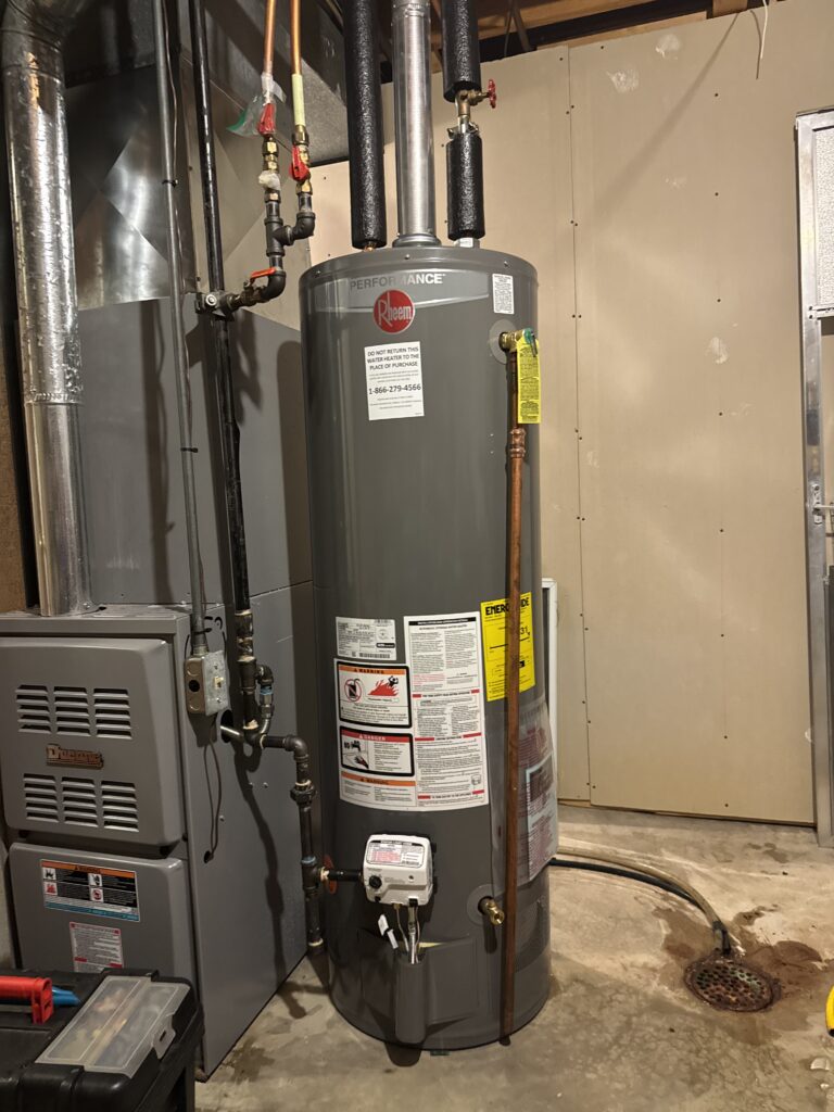 Water heater installation in Oakville, MO: new gas tank water heater set beside the furnace in a South St. Louis County basement