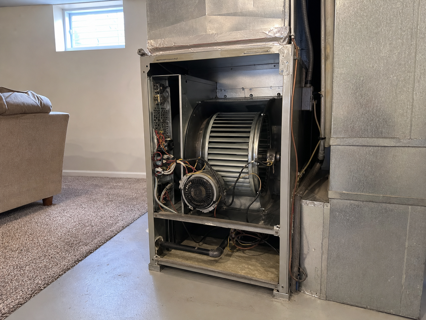 Indoor air handler in a finished residential basement with the access panel removed (should you turn off AC if making loud noise in St. Louis)