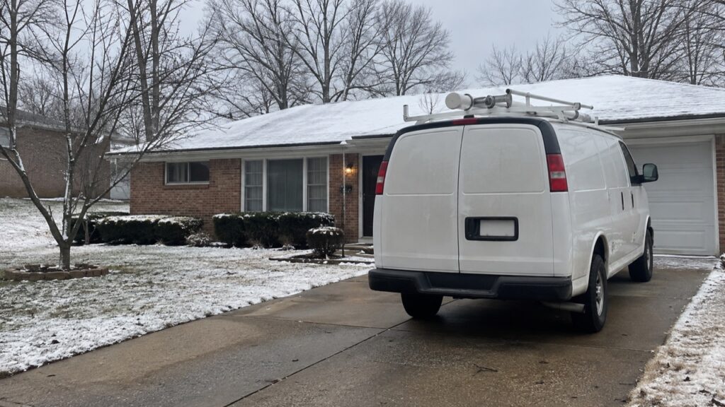 Furnace repair near Rockport Heights Elementary: a service van parked outside a brick ranch in Arnold on a snowy winter morning