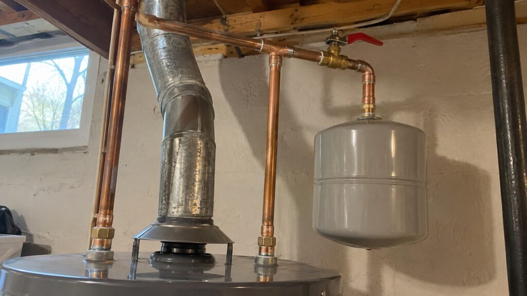 A thermal expansion tank installed on the cold water line above a new water heater in Imperial